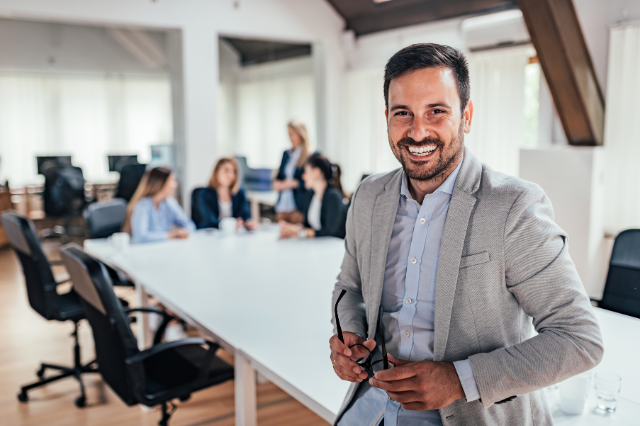 Business standing in front of partners or team, conference table