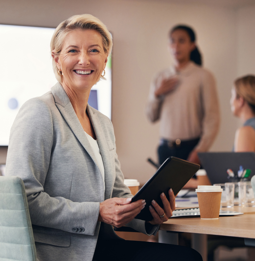 leadership team sitting at a conference table, woman in front